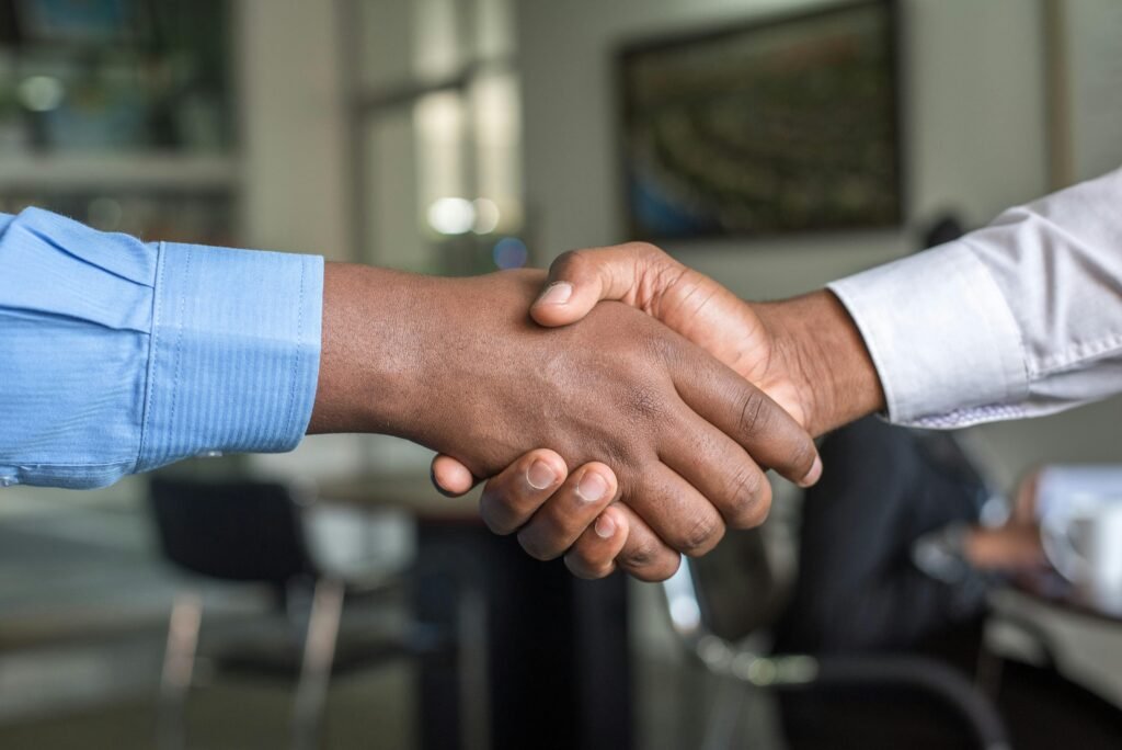 Two men handshaking at the end of a public sector leadership consulting meeting.